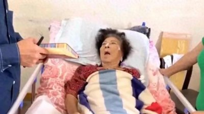 ​2021年，张灵甫遗孀王玉龄弥留之际的镜头，儿子拿着纸笔记录遗言